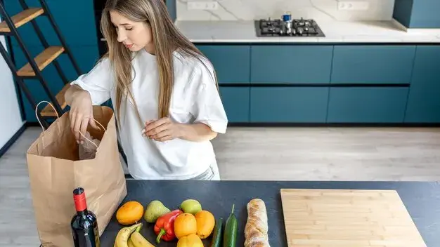 Compras recém-chegadas sobre a bancada da cozinha, com pão e frutas