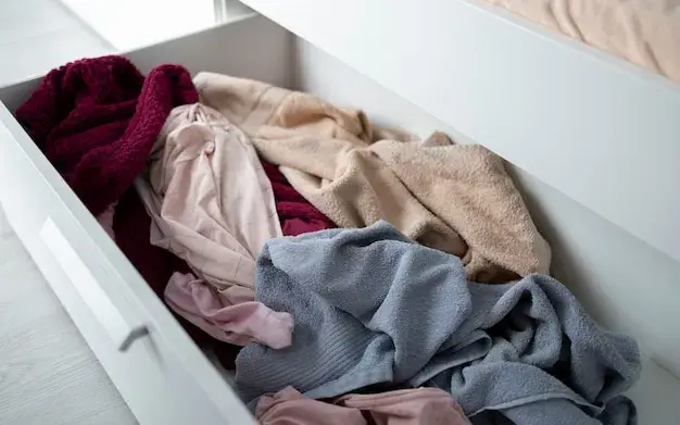 Gaveta aberta com roupas amontoadas sem dobra